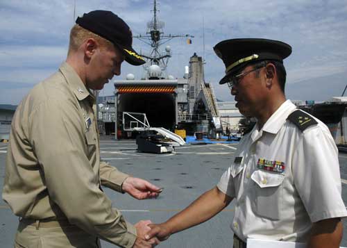 Here Captain Whalen is seen in his role as Commander of the amphibious transport dock USS Juneau presenting a coin to Captain Yasuhiro of the Japanese Ground Self Defense Force (Credit: USN, http://bit.ly/iXASHx)