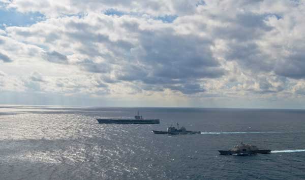 The littoral combat ship USS Freedom, the guided-missile cruiser USS Bunker Hill and the Nimitz-Class aircraft carrier USS Carl Vinson steam alongside each other in formation. (Credit: USN Visual Service 02/04/2010)