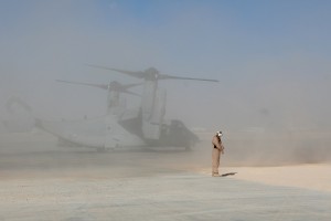 A Marine with Marine Aircraft Group 40 shields himself, Nov. 6, from the dirt and rocks blown around from the first wave of MV-22B 'Osprey' entering the Taskforce Helmand area of operation. Credit: 2nd Marine Expeditionary Brigade, 11/6/09 