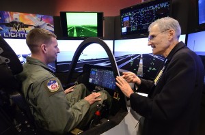 Senior Airman Michael Sterchi, a C-130 Loadmaster from the 700th Airlift Squadron, listens to Mr. Mike Skaff, chief engineer of pilot/vehicle interface for the F-35 program, for some pointers on flying an F-35C off the carrier, 31 Aug.  Lockheed Martin held a special event for the press and invited guests at the Marietta facility with their F-35 Joint Strike Fighter cockpit demonstrator as the focal point.  (U.S. Air Force photo/ Brad Fallin) 9/1/11 