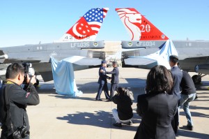 Gen. Hawk Carlisle (left), Pacific Air Forces commander, and Maj. Gen. Hoo Cher Mou, Republic of Singapore chief of air forces, shake hands after unveiling two newly-painted F-16 tail flashes following the Peace Carvin II Parade Dec. 11, 2013. The painted tail flashes commemorate the 20th anniversary of the RSAF partnering with Luke Air Force Base in training fighter pilots. (U.S. Air Force photo by Staff Sgt. Luther Mitchell Jr.) 