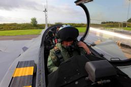 Maj. Eric Grunke, an AV-8B Harrier instructor pilot, Marine Aviation Weapons and Tactics One, Yuma, Ariz., straps on his aviator helmet and checks his communications before support a rehearsal of Close Air Support and Forward Air Controller (Airborne) operations with Swedish aviators from the Swedish Air Force Operation, Tactics and Procedures division and SwAF UH-60 Black Hawk Helicopters from the 21st Black Hawk Helicopter Wing. Marine aviation instructors from Marine Air Weapons and Tactics One, Yuma, Ariz., introduced Forward Air Controller (Airborne) and Close Air Support concepts, tactics, and procedures for evaluation into the Swedish Air Force's aviation training with SwAF pilots from the 21st UH-60 Black Hawk Helicopter Wing and the JAS-39 Grippen Operations, Tactics and Evaluations division, August 5-23 2013 at Malmen Military Base, Linköping, Sweden. Credit: MAWTS-1 