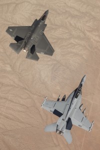  MOJAVE DESERT, Calif. (Aug. 28, 2014) A U.S. Navy F/A-18F Super Hornet assigned to the Dust Devils of Air Test and Evaluation Squadron (VX) 31 at Naval Air Weapons Station China Lake, Calif., conducts an interoperability test event with a Navy F-35C Lightning II joint strike fighter aircraft over the Edwards Air Force Base test range with the Mojave Desert below. The two aircraft engaged in a series of electronic exchanges to ensure that communications and sensor information could be passed effectively between platforms. The F-35C is the Navy's variant of the joint strike fighter, designed to operate at sea on aircraft carriers and is scheduled for initial deployment in 2019. (U.S. Navy photo courtesy of Lockheed Martin by Matt Short/Released) 