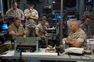 MajGen Richard L. Simcock, commanding general of 2d MEB, talks with LtCol (LtCol) Wayne Waltrip, Force Effects Coordinator, and his staff aboard the USS Iwo Jima, Oct. 29, 2014. Simcock and RAdm Cynthia Thebaud took command aboard the USS Iwo Jima within 24 hours after receiving the order by executing an experimental FICE (Fly-In Command Element) concept aboard the USS Iwo Jima off the coast of North Carolina. The FICE, part of the Marine's Expeditionary Force 21 Concept, was one of many experiments conducted during Exercise Bold Alligator 2014.