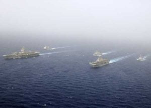 Ships of the Kearsarge Amphibious Ready Group and the Enterprise Carrier Strike Group steam in close formation for a scheduled photographic exercise known as a PHOTOEX. (Credit: USN Visual Service 2/16/2011)